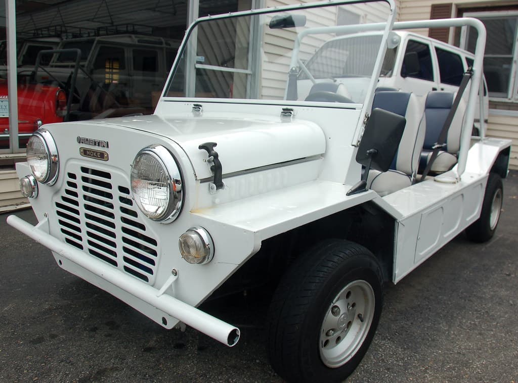 Old cars at Copley Motorcars, Needham MA: 1967 Austin Mini Moke, with the Maserati in the window beyond, and the unknown minivan behind it