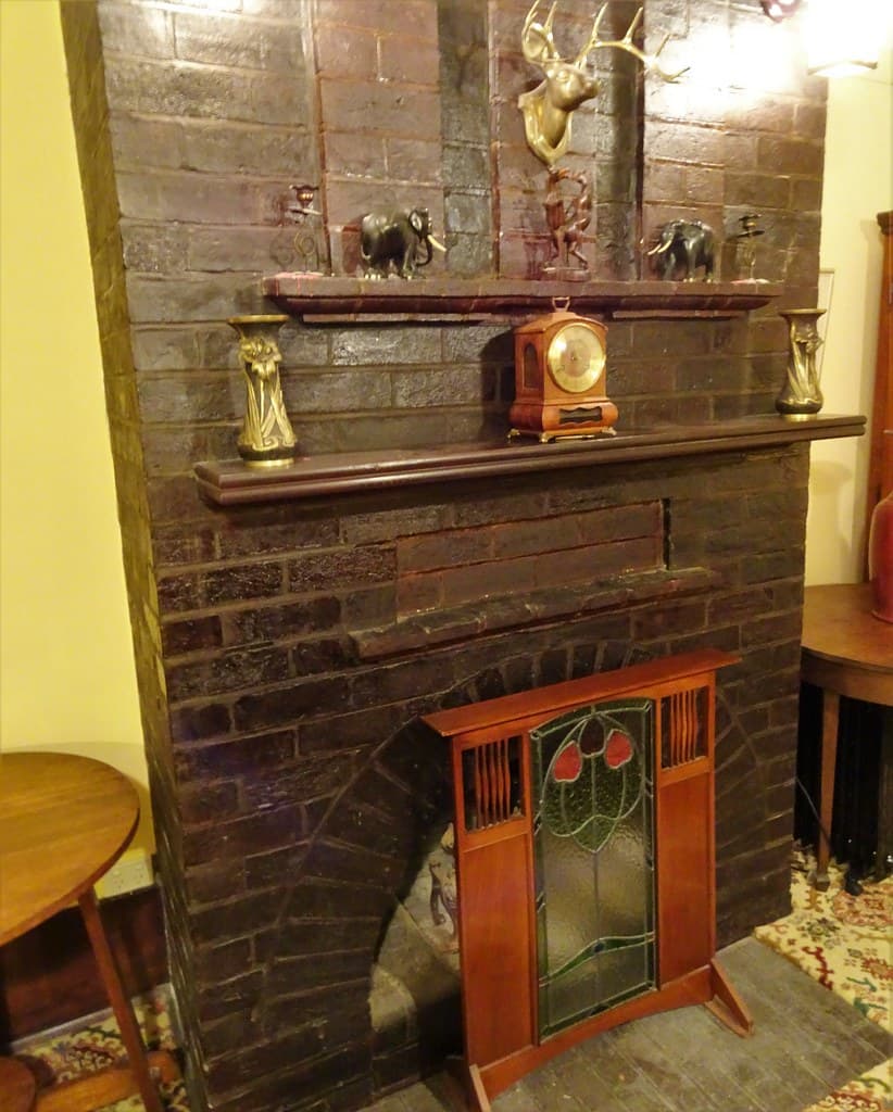 Grange. Adelaide. N'Kola Donga House built in 1912. Dark brick fireplace with pretty Art Deco fire screen in front. .
