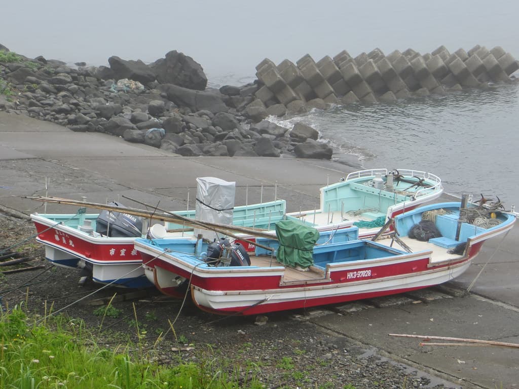 Two beached fishing boats and breakwater