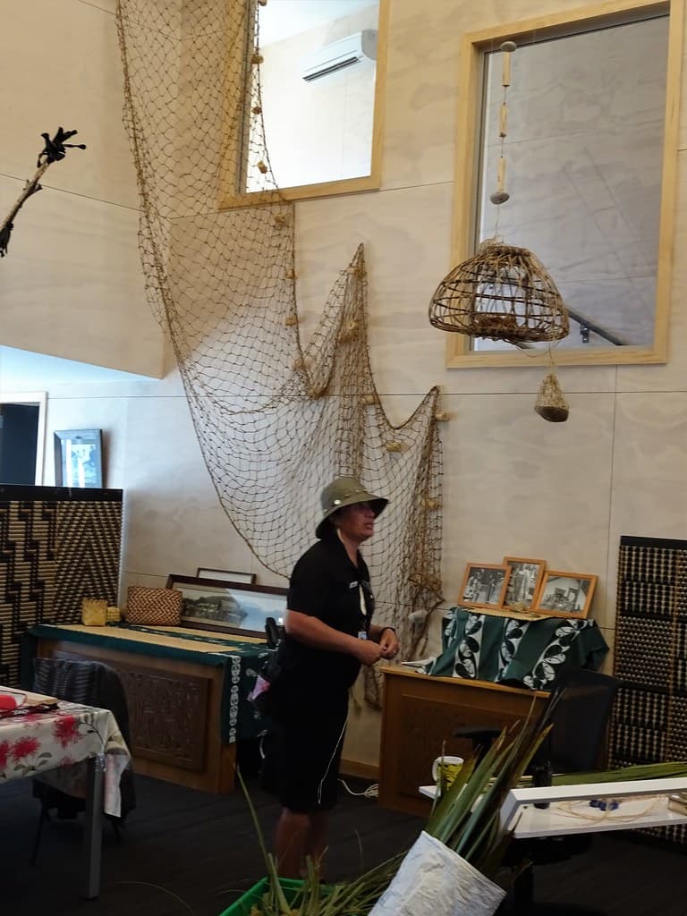 Rotorua. At Whakarewarewa Living Maori Village  in the womans weaving school a Maori woman explains the use of flax leaves in traditional weaving.