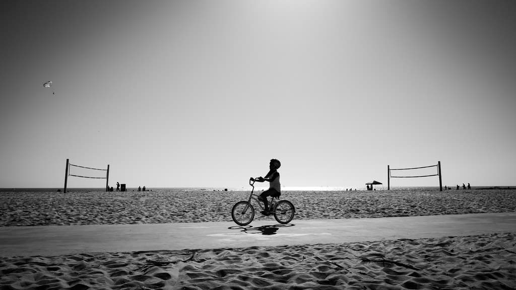 A boy cycling in Venice Beach - Los Angeles, United States - Black and white street photography