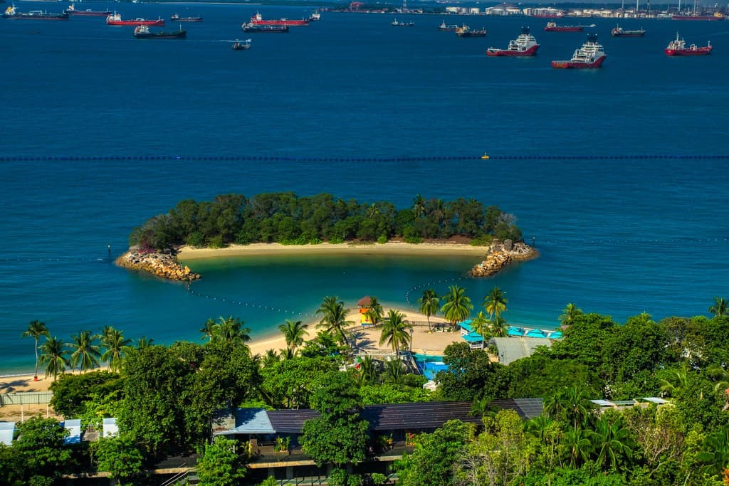 Beach on Sentosa island with ships in the roadstead in Singapore