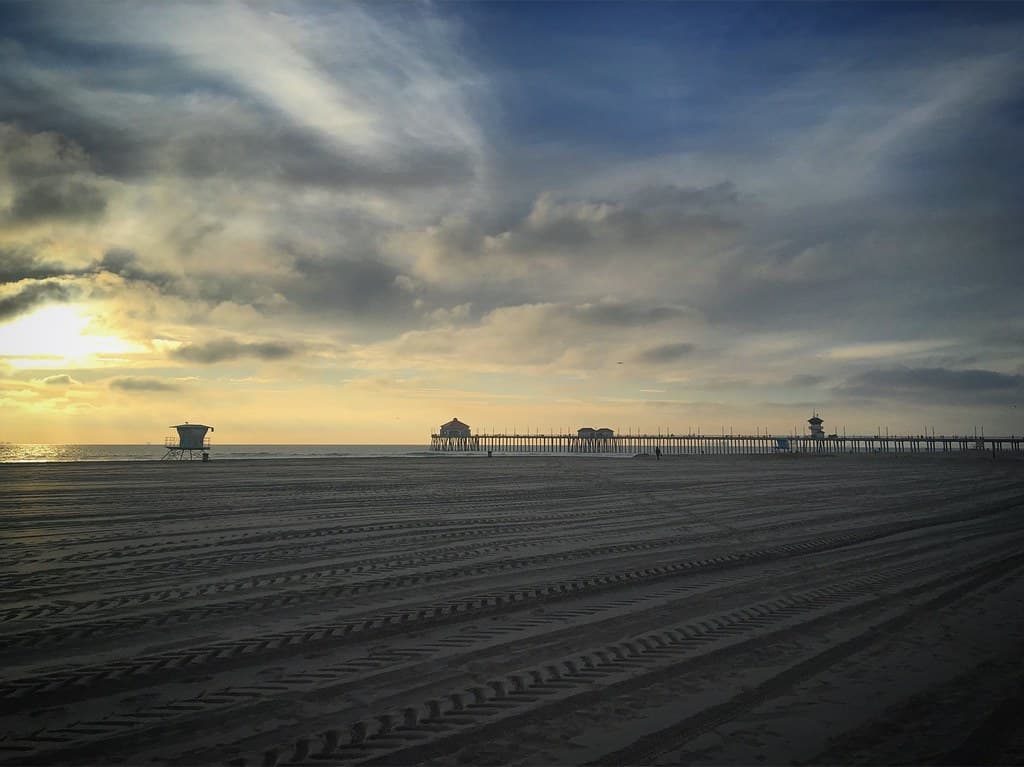Cloudy sky sunset at Huntington Beach with pier and lifeguard tower, California, USA, January 2019