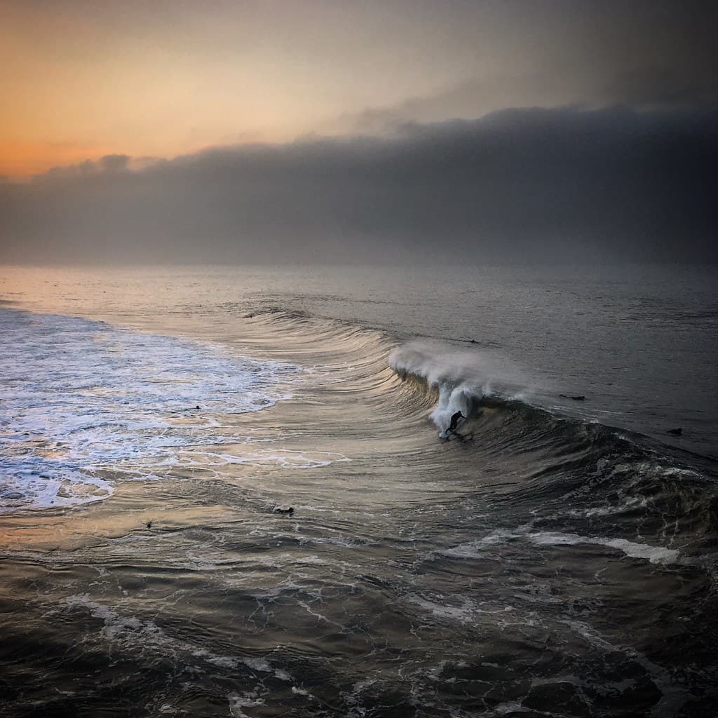 Sunset over the waves of the Pacific ocean near Huntington Beach, California, USA, January 2019