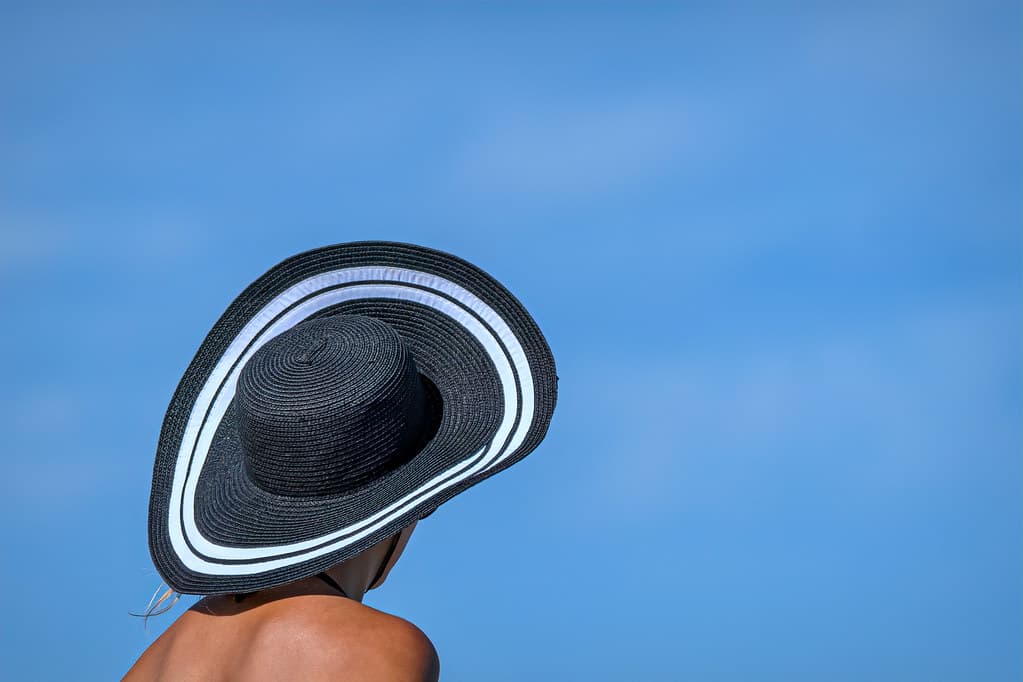 Black sun hat and tanned shoulders on Palm Beach Municipal Beach, Palm Beach, Florida