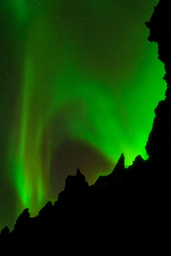 Stars and Northern Lights over large lava rock formations in Svörtulón (the Black Lagoon) at sunset at Djúpalónssandur (Black Sand Beach) in Snæfellsjökull National Park, Snæfellsnes, Western Iceland