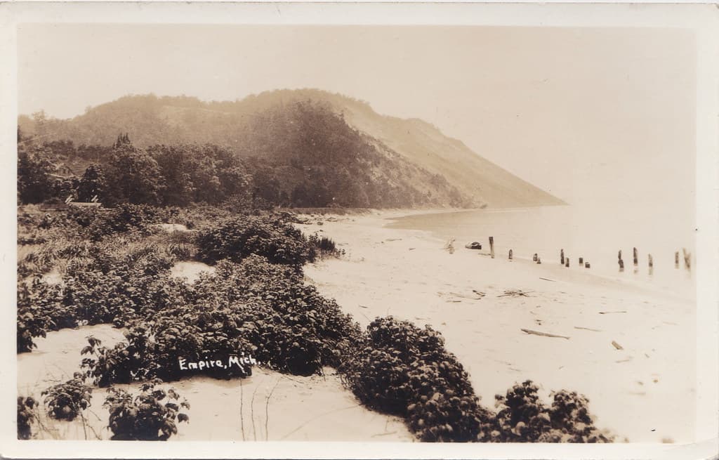 NW Empire Leelanau MI RPPC 1908 Landmark called The Sailors Apron at Empire Bluffs Old Steamer Ferry & EMPIRE LUMBER CO. Docks ruins at Empire Beach Photographer HERBERT of Traverse City
