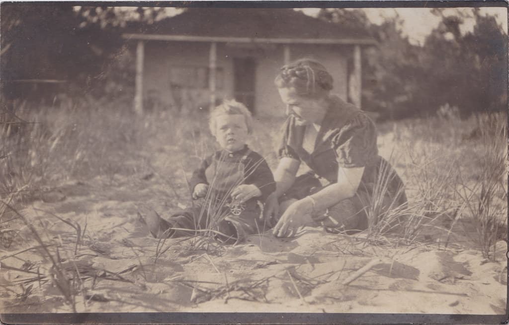 NW Arcadia MI RPPC c.1918 LITTLE GEORGE son of Ray & Anna Edwards on the beach in front of a Arcadia Waterfront Cottage Photo by Hardware Store Manager & Photographer Ray Edwards