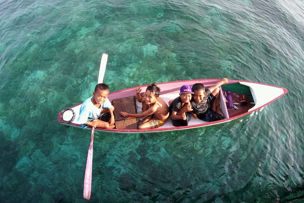 Happy kids at Derawan island on wooden boat