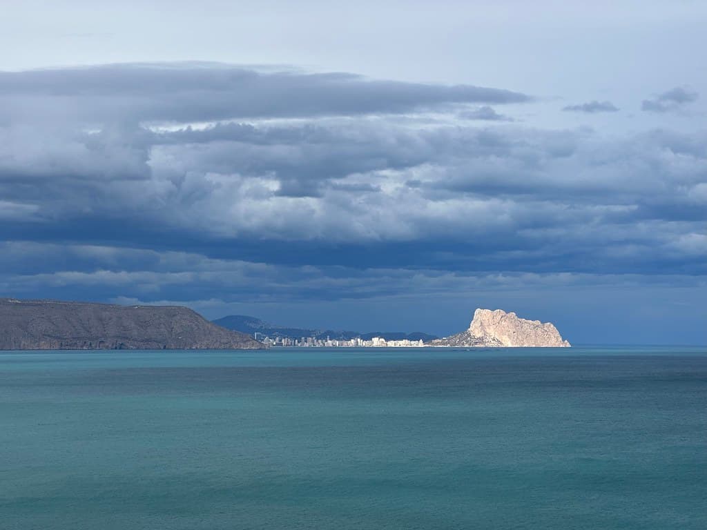 View of the Mediterranean Sea coast near Calpe with sunlit Penyal d'Ifac from l'Alfàs del Pi, Valencian Community, Spain, March 2024