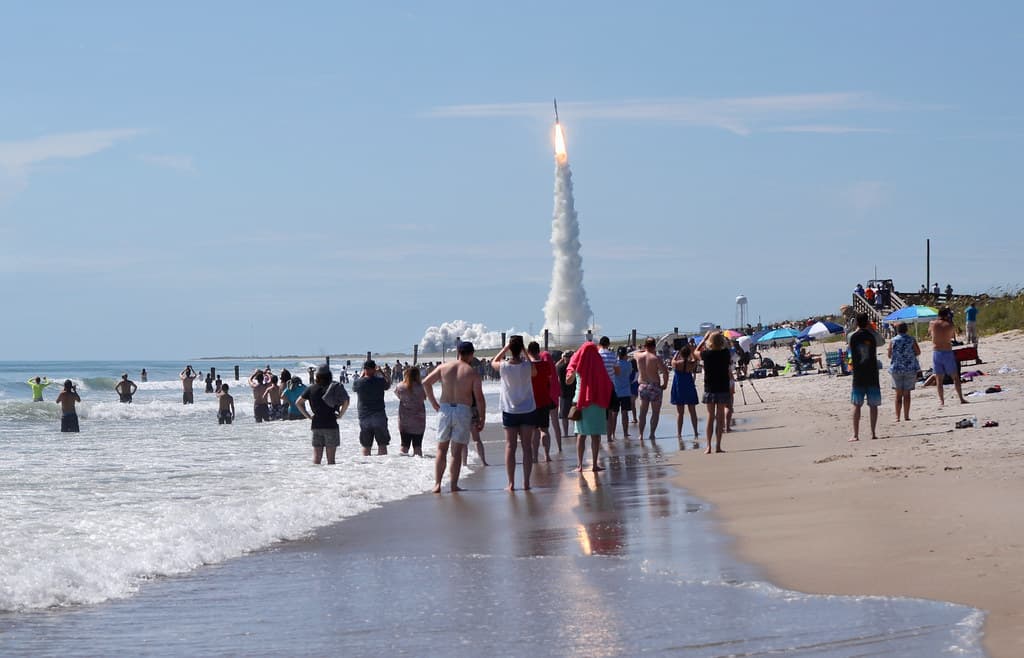 An Atlas V rocket puts on a show for beachgoers as it lifts a massive U.S. Navy satellite into orbit.